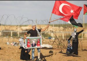 מפגין בעזה מחזיק את דגל טורקיה ותמונתו של ארדואן