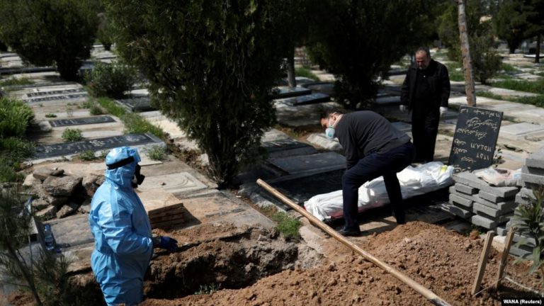 Relatives bury השפעות הקורונה : journalist Abdollah Zavieh, who passed away due to coronavirus disease (COVID-19), at Behesht Zahra cemetery in Tehran, March 24, 2020